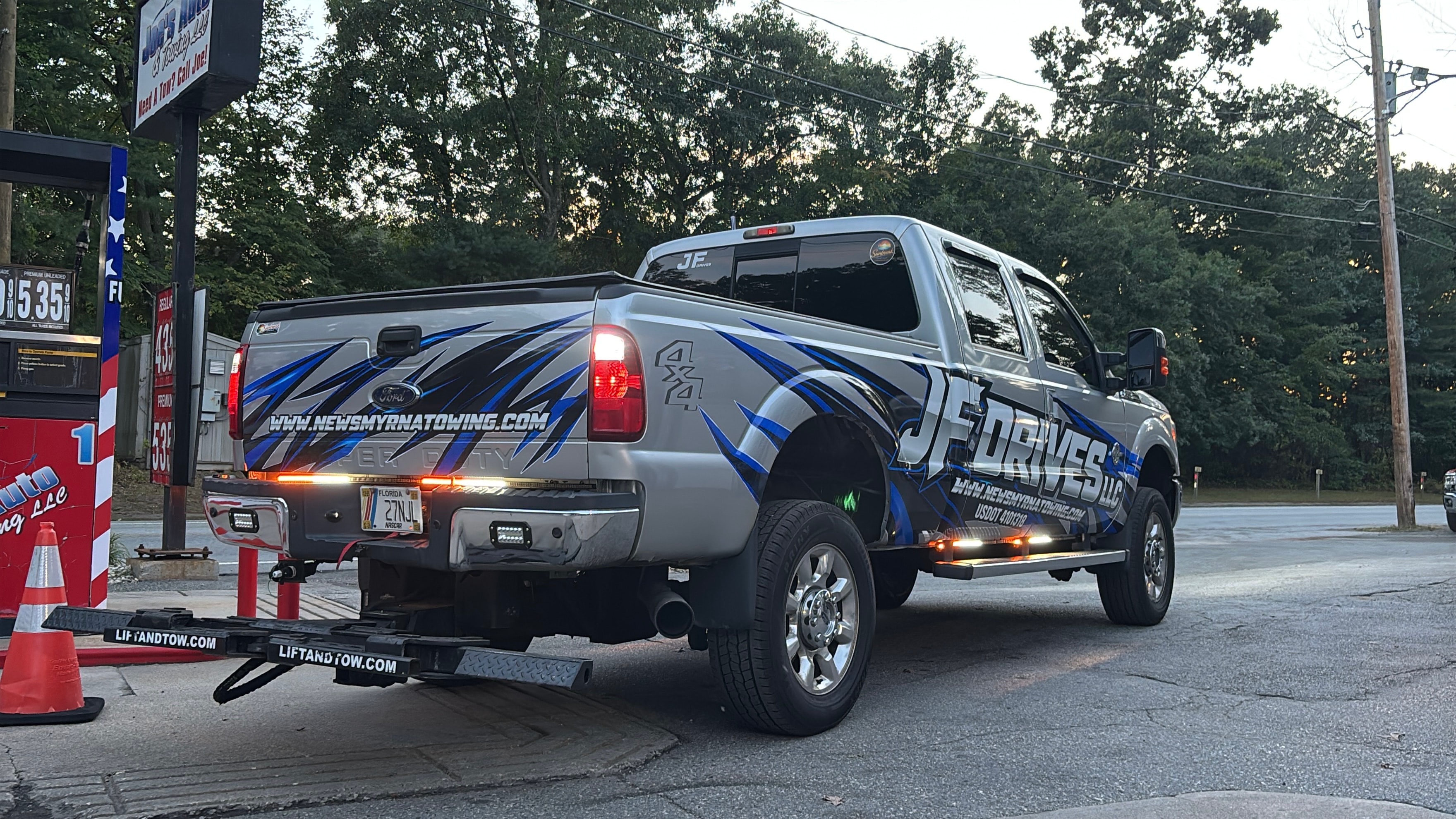 JF Drives truck carrying a silver pickup truck