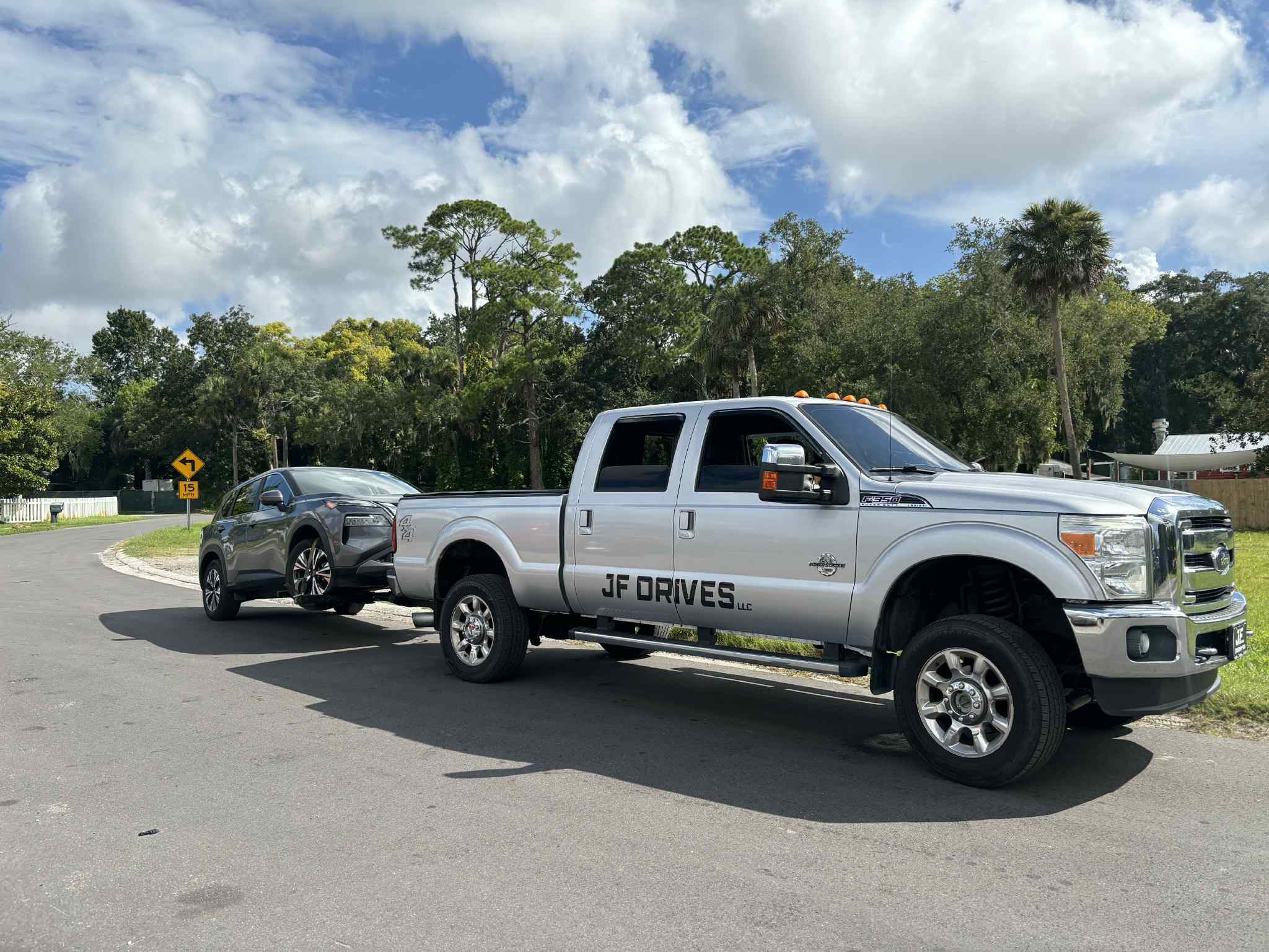 JF Drives towing a sedan on a residential road