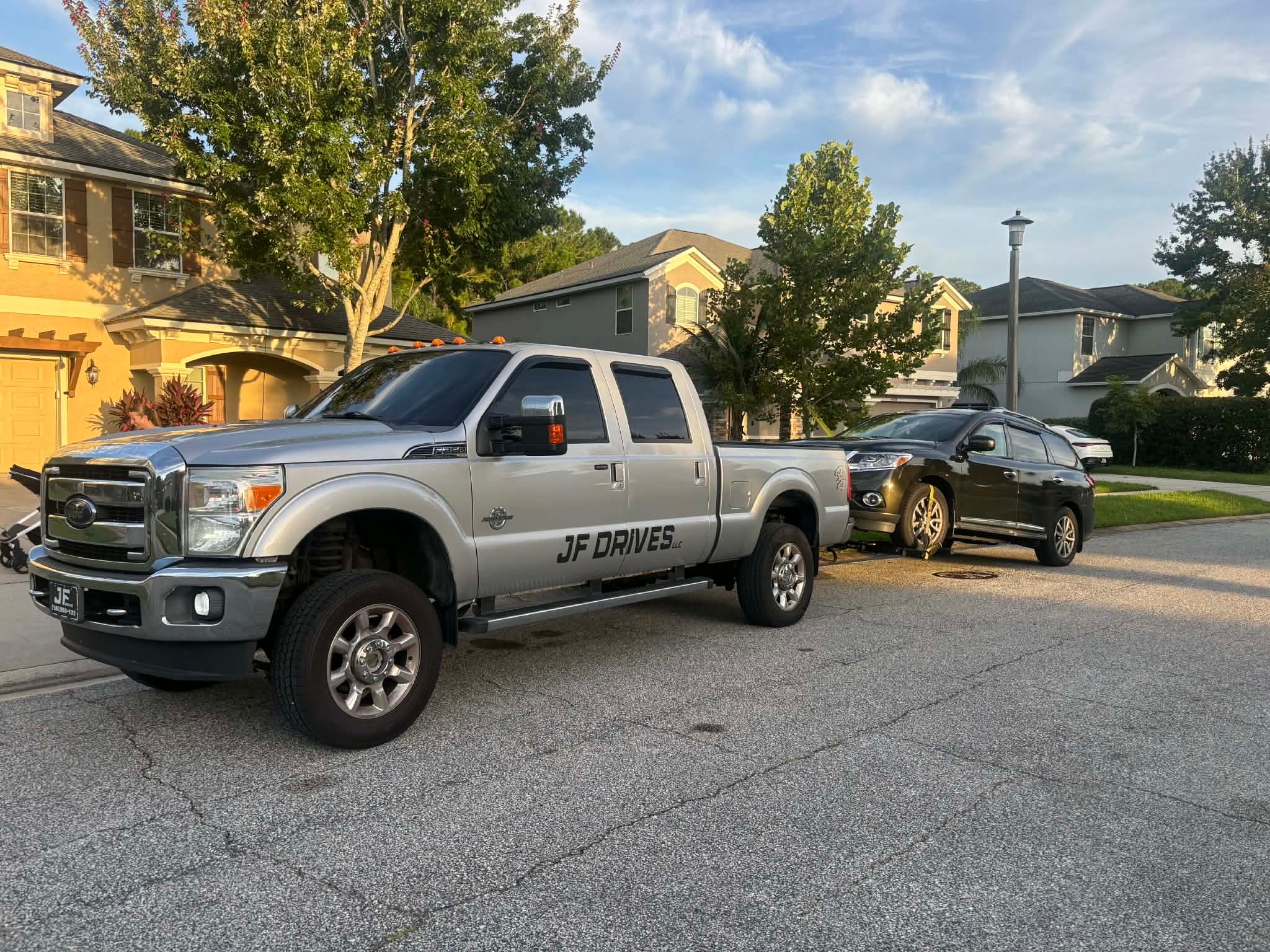 JF Drives LLC tow trucks in a residential driveway in Edgewater, Florida