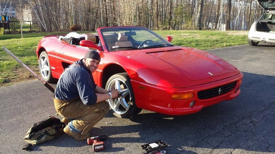 JF Drives technician performing roadside tire service on a red Ferrari convertible